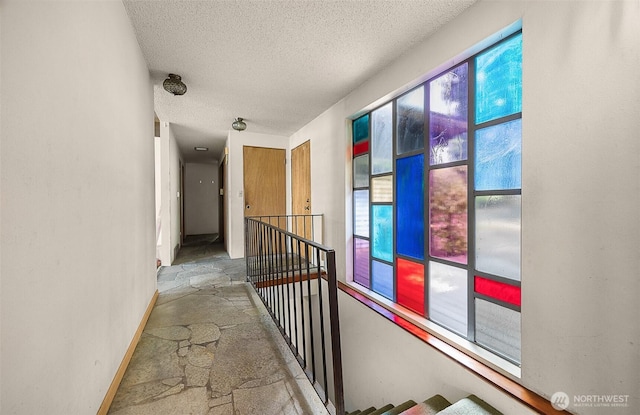 1711 E Lake Sammamish Pl SE, Sammamish, WA 98075 - hall featuring an upstairs landing, stone floors, and a textured ceiling