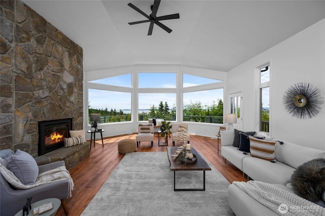 3995 Bay Ln, Anacortes, WA 98221 - living area with vaulted ceiling, ceiling fan, a stone fireplace, and wood finished floors