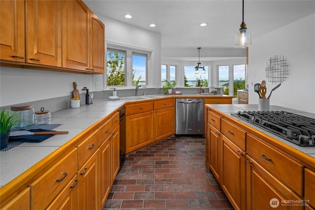 3995 Bay Ln, Anacortes, WA 98221 - kitchen with dishwasher, black gas cooktop, tile counters, recessed lighting, and brick flooring