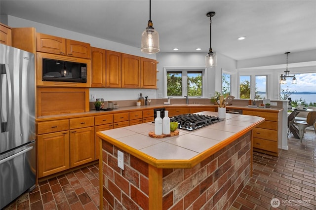 3995 Bay Ln, Anacortes, WA 98221 - kitchen featuring stainless steel appliances, tile counters, brick flooring, a kitchen island, and recessed lighting