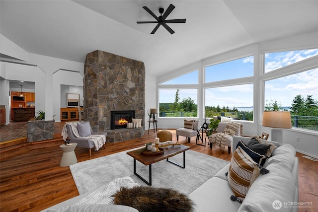 3995 Bay Ln, Anacortes, WA 98221 - living area with a stone fireplace, a ceiling fan, wood finished floors, and high vaulted ceiling