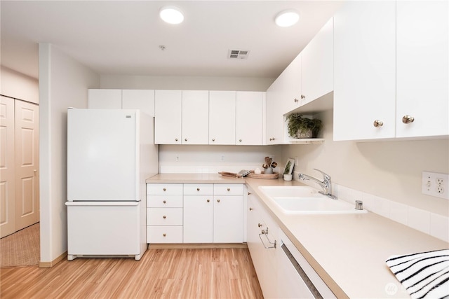 1318 37th St Unit 2-428, Everett, WA 98201 - kitchen with freestanding refrigerator, light wood finished floors, light countertops, and white cabinetry