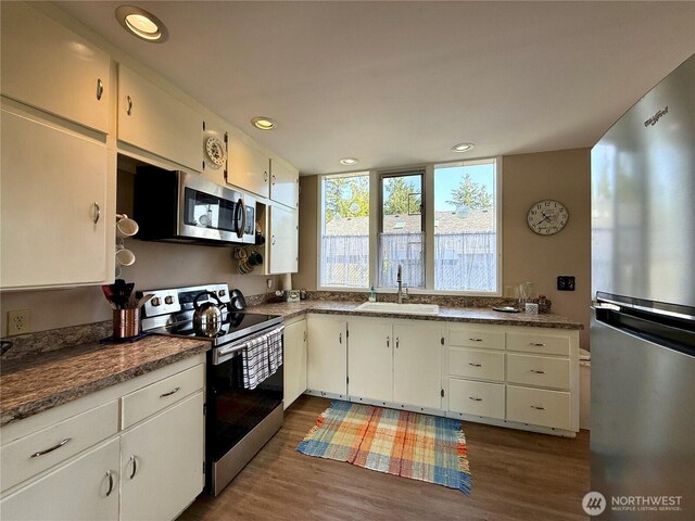 877 Mount Olympus Ave SE, Ocean Shores, WA 98569 - kitchen with appliances with stainless steel finishes, dark wood-style floors, recessed lighting, and white cabinetry