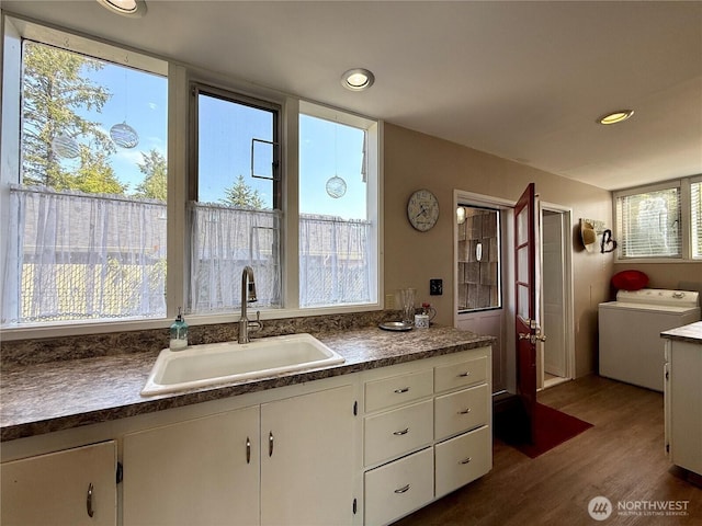 877 Mount Olympus Ave SE, Ocean Shores, WA 98569 - kitchen with washer / clothes dryer, dark wood-type flooring, white cabinetry, dark countertops, and recessed lighting