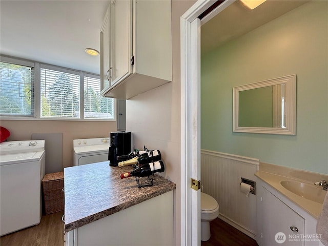 877 Mount Olympus Ave SE, Ocean Shores, WA 98569 - bathroom featuring washer and dryer, wood finished floors, wainscoting, and vanity