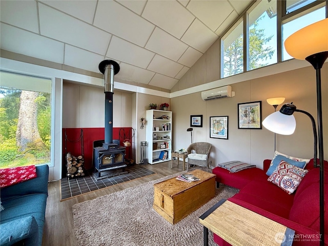 877 Mount Olympus Ave SE, Ocean Shores, WA 98569 - living area with a wood stove, a wall mounted air conditioner, wood finished floors, plenty of natural light, and a high ceiling