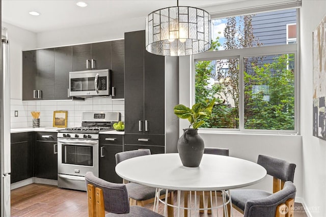 1110 Martin Luther King Jr Way S Unit A, Seattle, WA 98144 - kitchen featuring stainless steel appliances, dark cabinets, light wood-style flooring, light countertops, and decorative backsplash