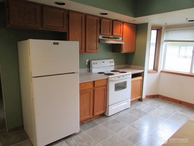 725 W Main, Morton, WA 98356 - kitchen with white appliances, under cabinet range hood, light countertops, and brown cabinets