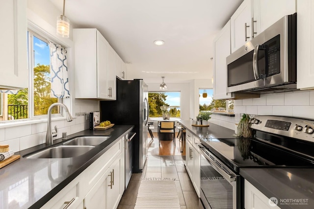 11515 Greenwood Ave N Unit C, Seattle, WA 98133 - kitchen with appliances with stainless steel finishes, dark countertops, white cabinets, and recessed lighting