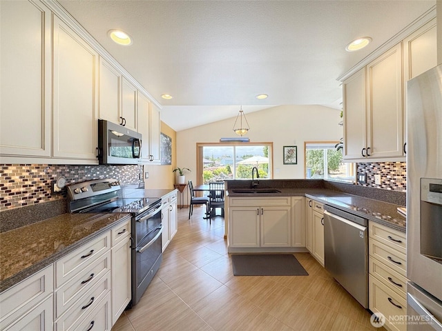 206 Buckhorn, Sequim, WA 98382 - kitchen with stainless steel appliances, a peninsula, vaulted ceiling, tasteful backsplash, and hanging light fixtures