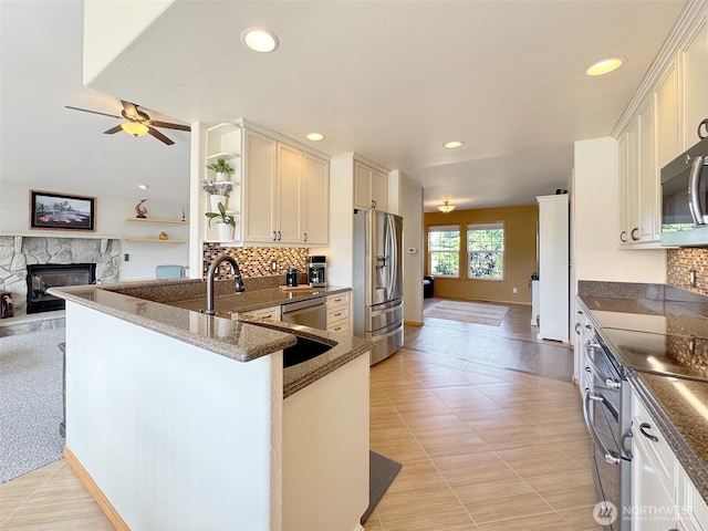 206 Buckhorn, Sequim, WA 98382 - kitchen with stainless steel appliances, a fireplace, backsplash, open floor plan, and recessed lighting