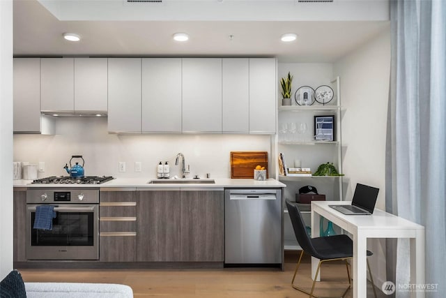 800 Columbia St Unit 1708, Seattle, WA 98104 - kitchen featuring appliances with stainless steel finishes, modern cabinets, light countertops, light wood-type flooring, and recessed lighting