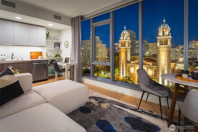 800 Columbia St Unit 1708, Seattle, WA 98104 - living room with light wood finished floors, floor to ceiling windows, and a view of city lights