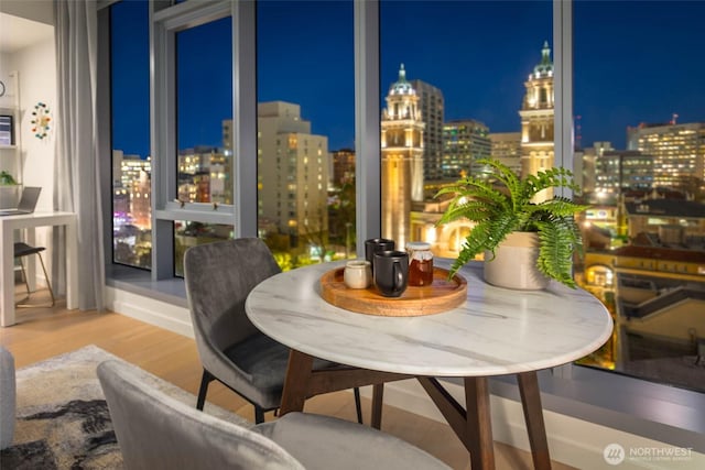 800 Columbia St Unit 1708, Seattle, WA 98104 - dining room featuring a view of city lights and wood finished floors