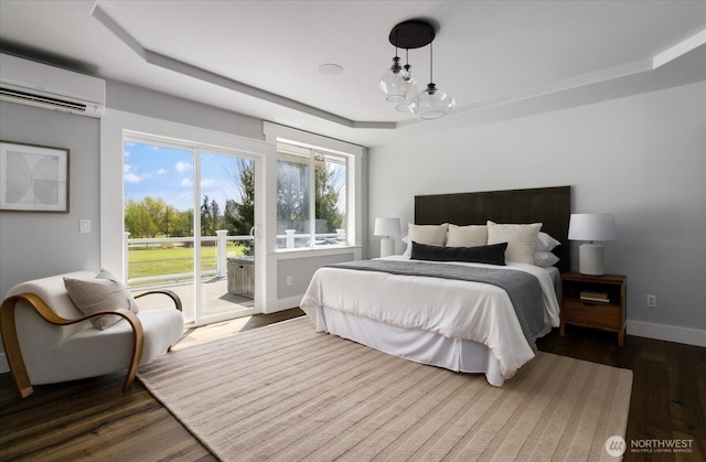 5681 Lenz Pl, Langley, WA 98260 - bedroom featuring a wall mounted air conditioner, a raised ceiling, access to exterior, and dark wood finished floors