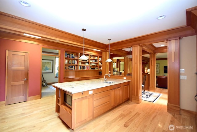 133 Fairway Pl, Sequim, WA 98382 - kitchen featuring open shelves, stainless steel microwave, hanging light fixtures, light wood finished floors, and light stone countertops