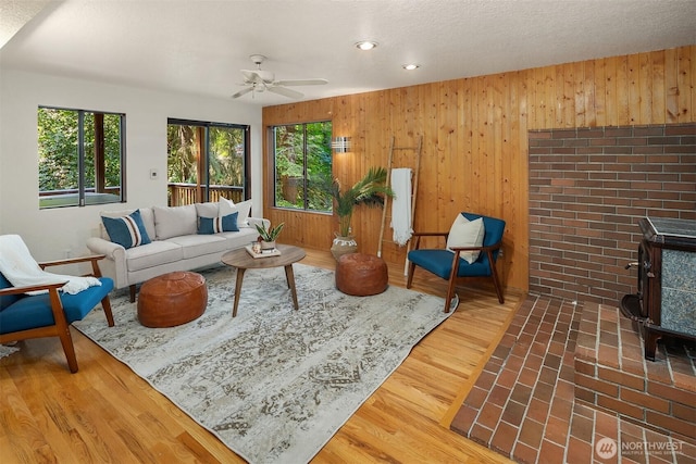 1820 NE 177th St, Shoreline, WA 98155 - living area with plenty of natural light, a wood stove, wooden walls, a ceiling fan, and recessed lighting