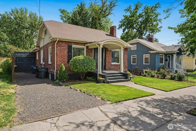 12 Newell St, Walla Walla, WA 99362 - view of front of house with a chimney, a storage shed, brick siding, and a front yard