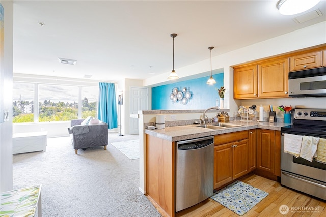 3201 Pacific Ave Unit 403, Tacoma, WA 98418 - kitchen with stainless steel appliances, a peninsula, decorative light fixtures, brown cabinets, and open floor plan