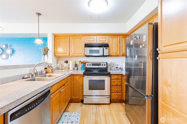 3201 Pacific Ave Unit 403, Tacoma, WA 98418 - kitchen with appliances with stainless steel finishes, light wood-style flooring, light countertops, and pendant lighting