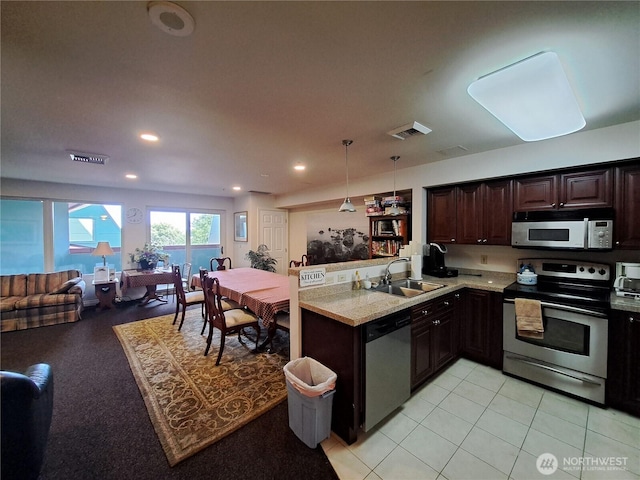 3201 Pacific Ave Unit 403, Tacoma, WA 98418 - kitchen with stainless steel appliances, open floor plan, dark brown cabinets, light countertops, and a peninsula
