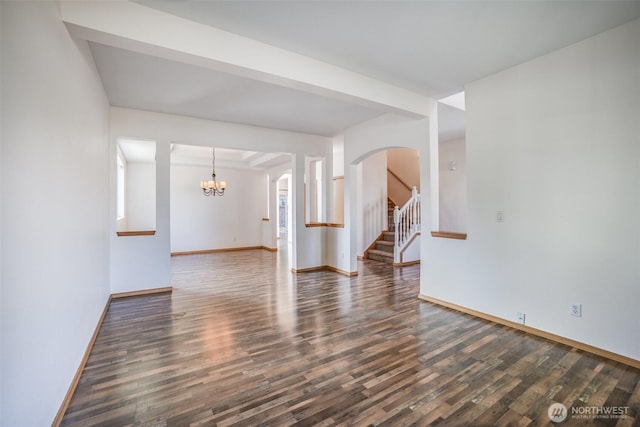 807 Williams St NW, Orting, WA 98360 - empty room featuring wood finished floors, a chandelier, arched walkways, and stairs