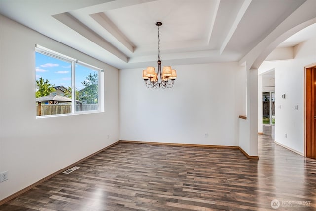 807 Williams St NW, Orting, WA 98360 - unfurnished room featuring a raised ceiling, wood finished floors, a chandelier, and arched walkways