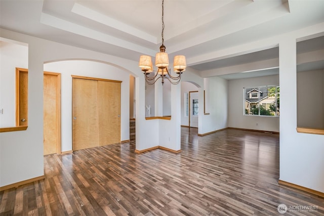 807 Williams St NW, Orting, WA 98360 - unfurnished room with a raised ceiling, a chandelier, wood finished floors, and arched walkways
