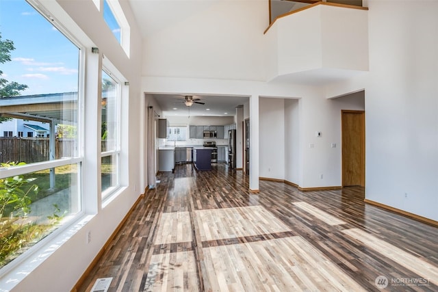 807 Williams St NW, Orting, WA 98360 - unfurnished living room with dark wood-style flooring, a high ceiling, healthy amount of natural light, and a ceiling fan