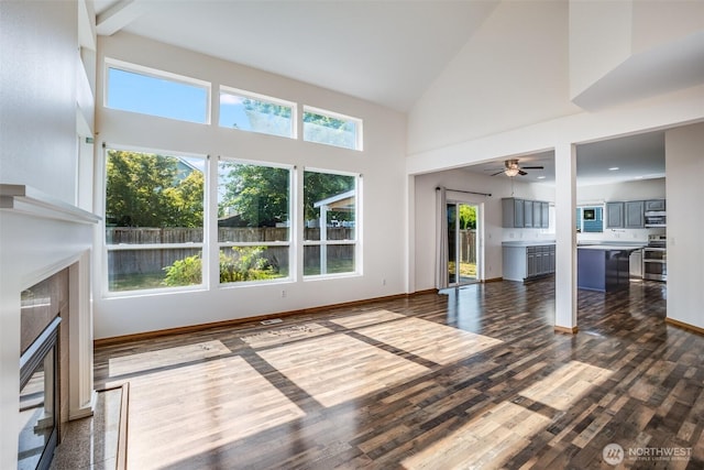 807 Williams St NW, Orting, WA 98360 - unfurnished living room with a fireplace, high vaulted ceiling, dark wood finished floors, and a ceiling fan