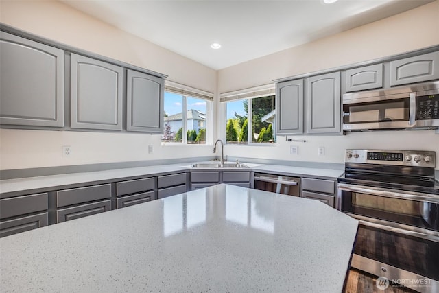 807 Williams St NW, Orting, WA 98360 - kitchen with appliances with stainless steel finishes, gray cabinets, recessed lighting, and light stone counters