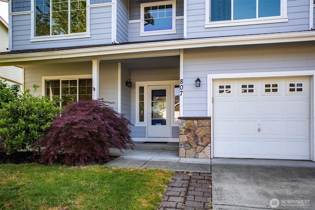 807 Williams St NW, Orting, WA 98360 - view of exterior entry featuring covered porch, a garage, and stone siding