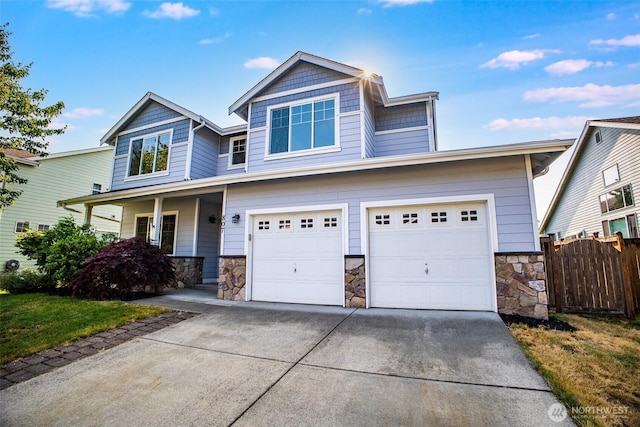 807 Williams St NW, Orting, WA 98360 - view of front of house with stone siding, concrete driveway, a garage, and a porch