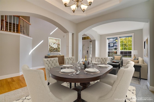 20313 194th Ave E, Orting, WA 98360 - dining space with arched walkways, a chandelier, crown molding, light wood-type flooring, and a tray ceiling