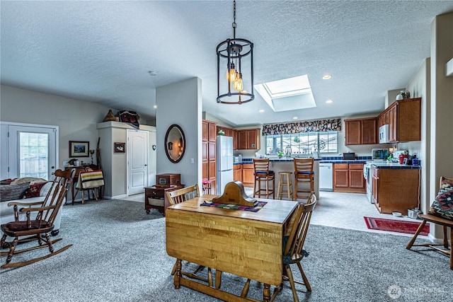 17612 19th Ave E Unit 83, Spanaway, WA 98387 - dining room with a skylight, a textured ceiling, light colored carpet, plenty of natural light, and vaulted ceiling