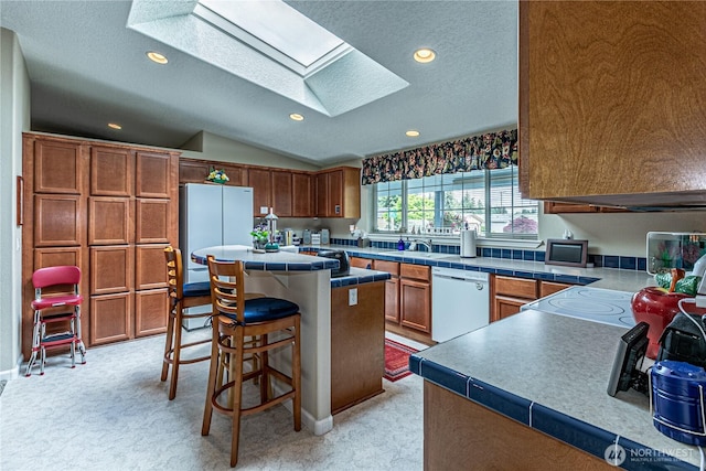 17612 19th Ave E Unit 83, Spanaway, WA 98387 - kitchen with dishwasher, freestanding refrigerator, a skylight, recessed lighting, and a kitchen island