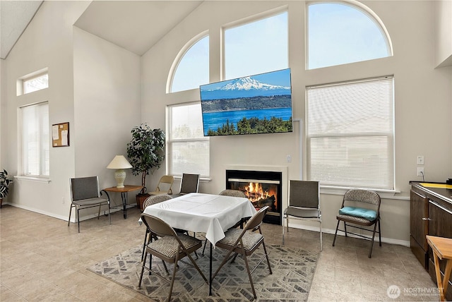 17612 19th Ave E Unit 83, Spanaway, WA 98387 - dining area featuring high vaulted ceiling, plenty of natural light, a glass covered fireplace, and light tile patterned floors
