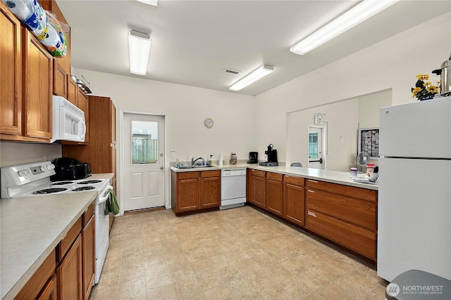 17612 19th Ave E Unit 83, Spanaway, WA 98387 - kitchen with white appliances, brown cabinetry, and light countertops