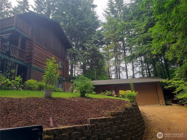 70 NE Wanda Ln, Belfair, WA 98528 - view of property exterior featuring a garage, dirt driveway, and log siding