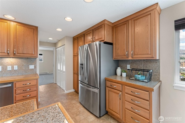 201 Pennsylvania Ave Unit 15, Wenatchee, WA 98801 - kitchen featuring appliances with stainless steel finishes, light countertops, backsplash, brown cabinets, and recessed lighting