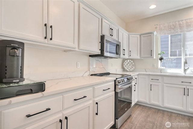 35055 41st Pl S, Auburn, WA 98001 - kitchen with stainless steel appliances, white cabinetry, light wood finished floors, light stone counters, and recessed lighting