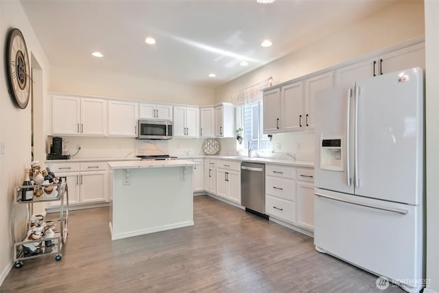 35055 41st Pl S, Auburn, WA 98001 - kitchen featuring appliances with stainless steel finishes, wood finished floors, a center island, light countertops, and white cabinetry