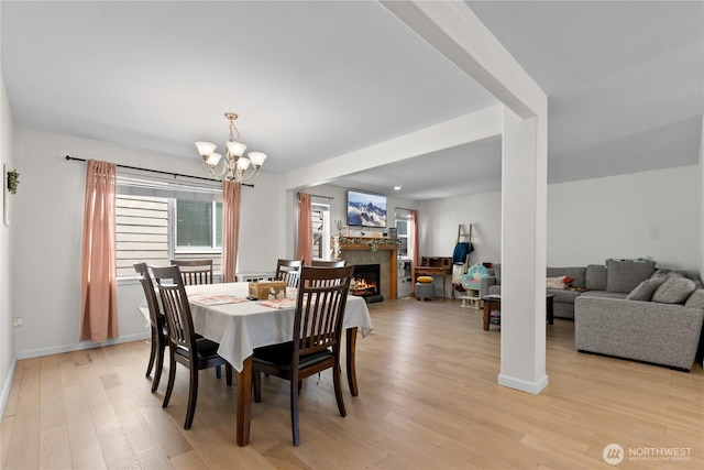 6974 Prism St SE, Lacey, WA 98513 - dining space featuring a chandelier, a lit fireplace, and light wood-style floors