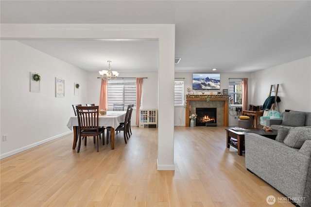 6974 Prism St SE, Lacey, WA 98513 - dining room featuring light wood-type flooring, a warm lit fireplace, and a chandelier