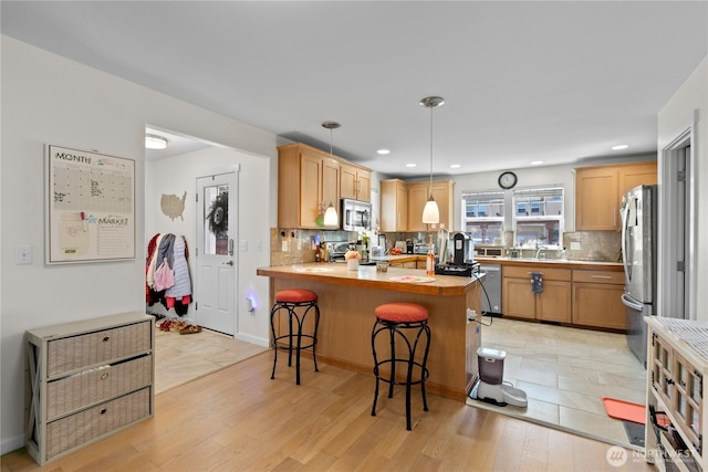 6974 Prism St SE, Lacey, WA 98513 - kitchen with appliances with stainless steel finishes, a peninsula, tasteful backsplash, light countertops, and recessed lighting