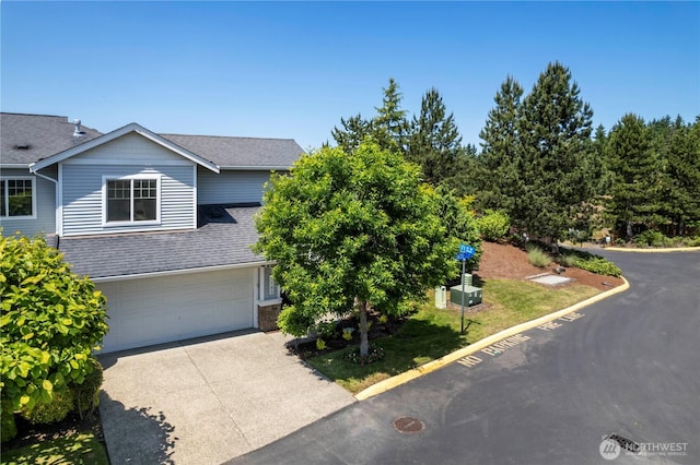 7103 Hazel Pl SE, Auburn, WA 98092 - view of front facade with driveway, an attached garage, and roof with shingles
