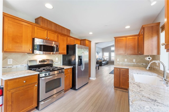 7103 Hazel Pl SE, Auburn, WA 98092 - kitchen featuring stainless steel appliances, decorative backsplash, light wood-type flooring, light stone countertops, and recessed lighting