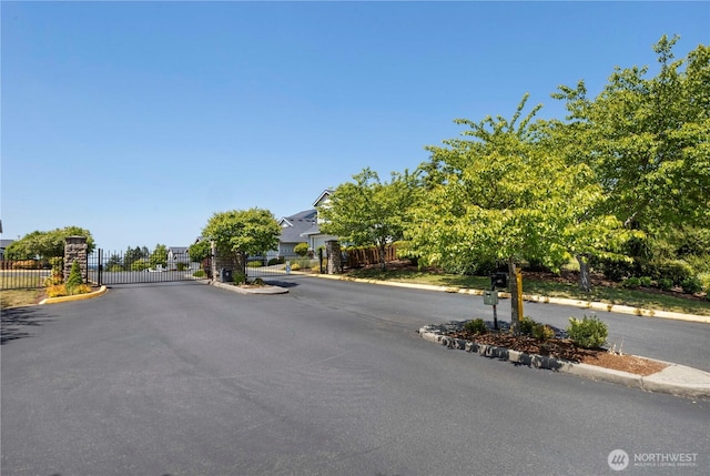 7103 Hazel Pl SE, Auburn, WA 98092 - view of asphalt road featuring curbs, a gate, and a gated entry