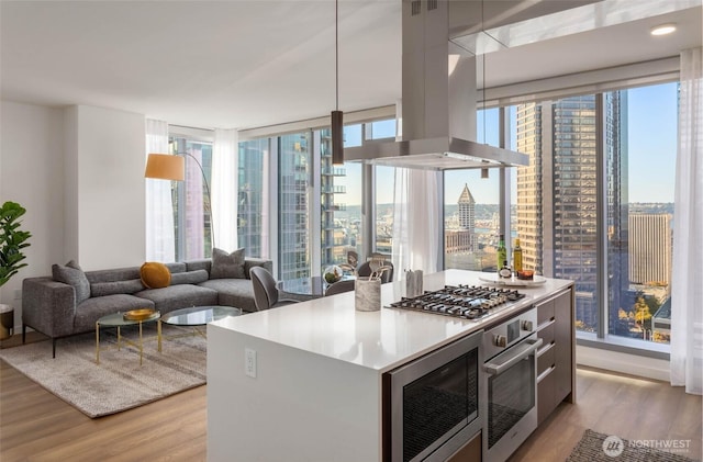 800 Columbia St Unit 2503, Seattle, WA 98104 - kitchen with island range hood, stainless steel appliances, light wood-style flooring, and a view of city