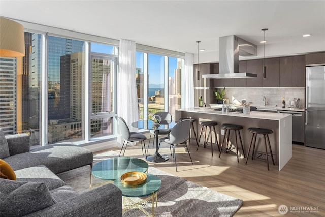 800 Columbia St Unit 2503, Seattle, WA 98104 - living room with light wood-style floors, floor to ceiling windows, and recessed lighting